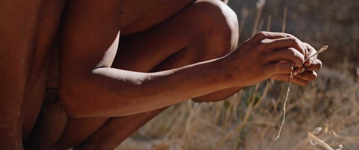 Tribal men in loincloth wrapping arrowhead