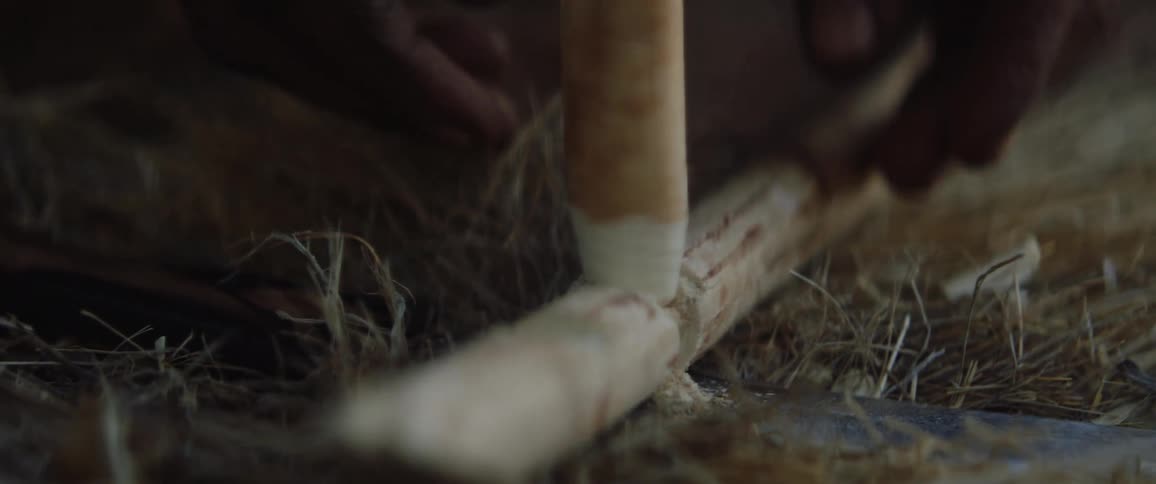 Tribal men use two sticks and grass to start a fire