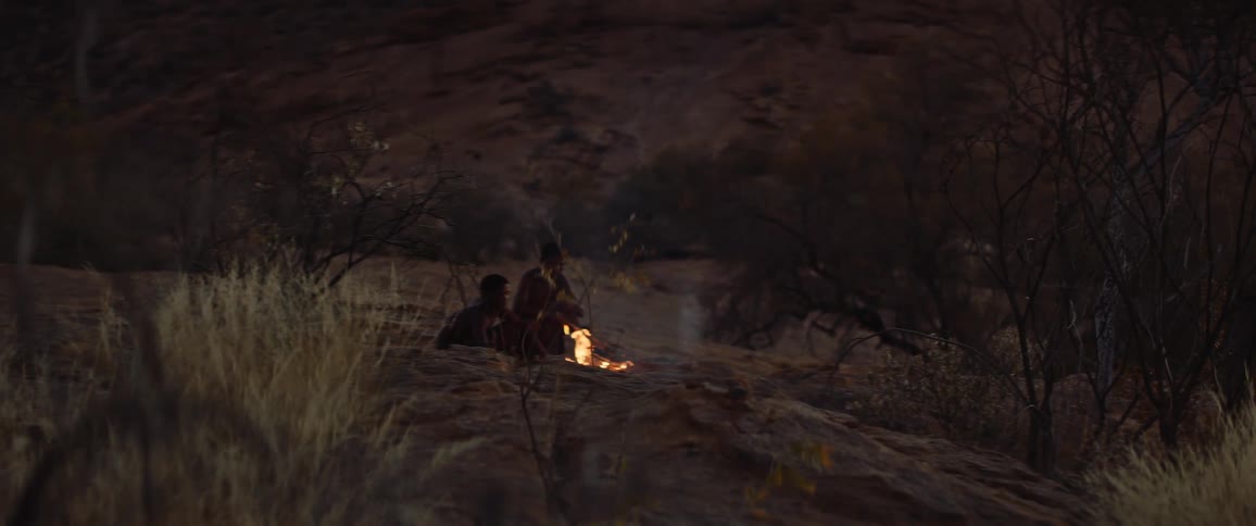 Tribal men sitting around a campfire in the savannah
