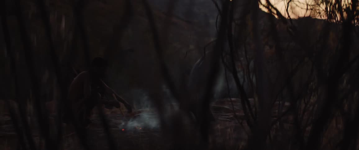 Indigenous people build a fire in the wilderness
