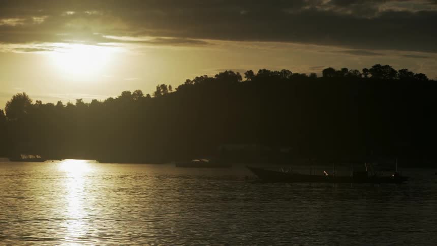 Boats sit still in the water at sunset