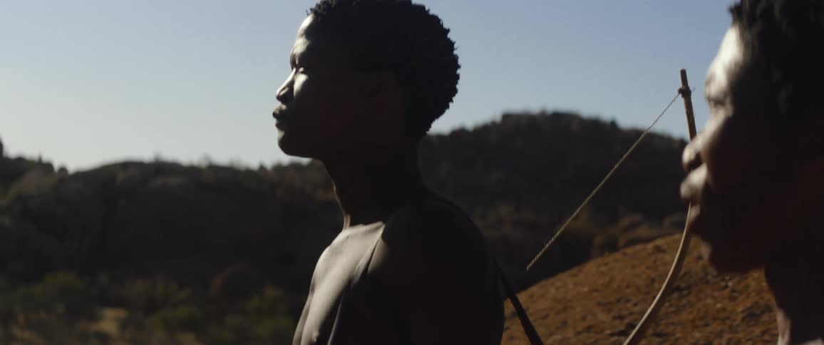 Indigenous hunters carrying bows talking and looking at the horizon