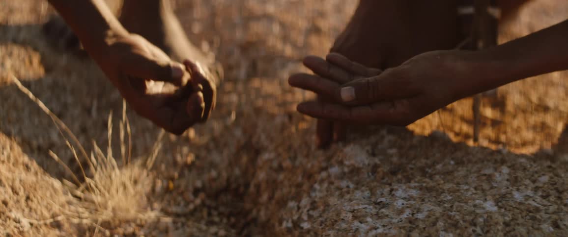 Tribal men examine spore on ground