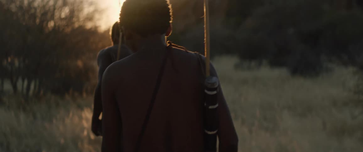 Tribal men with bows at sunset