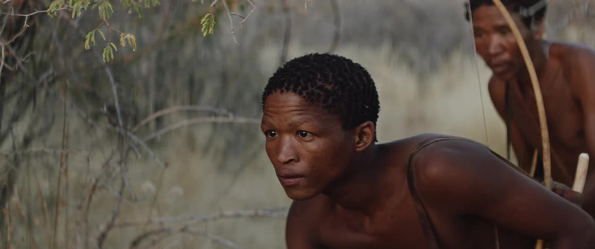 Tribal men with bows go hunting in african field