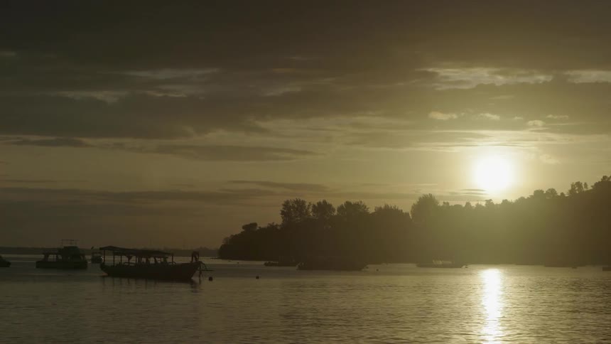 Boats are near the shore at sunset