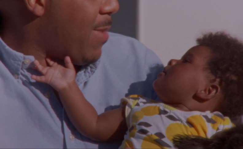 A father is holding his son indoors