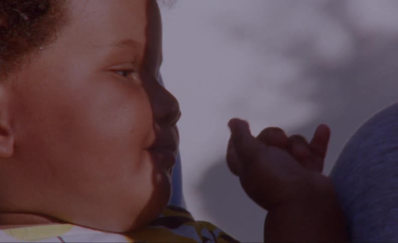 A baby flails while being held by a parent