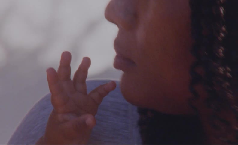 Mother playfully mouths at childs hand