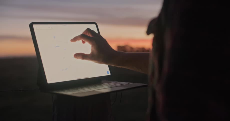 A man is using his laptop outside