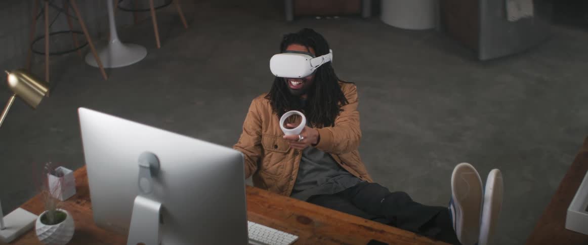 A man is playing virtual reality while sitting down