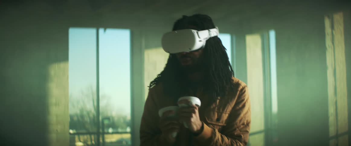 A man is using virtual reality and controllers