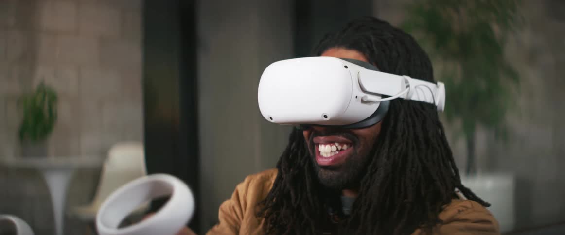 A man smiling while playing with a virtual reality head set