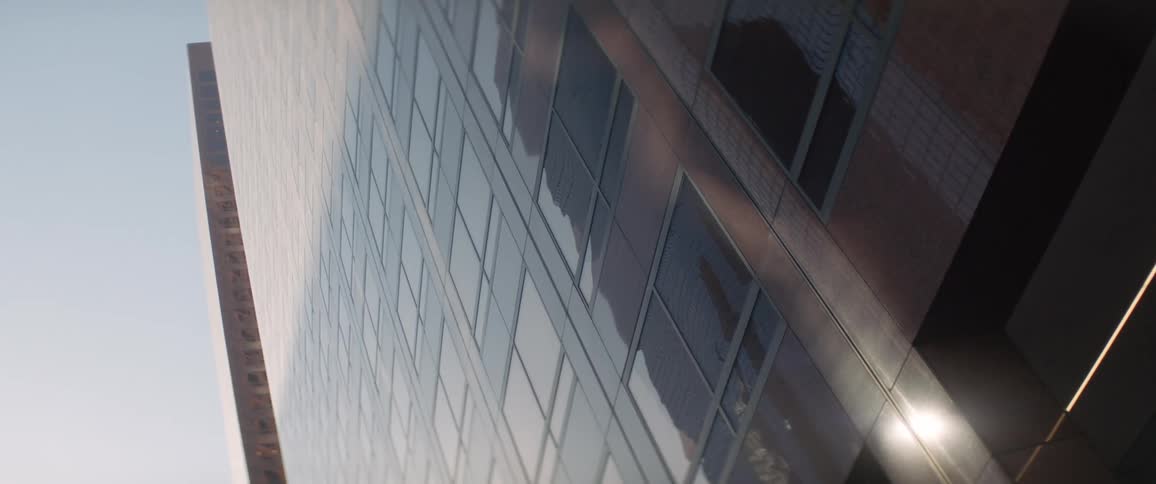 Sun shines on top of skyscraper while the bottom half remains in shadow