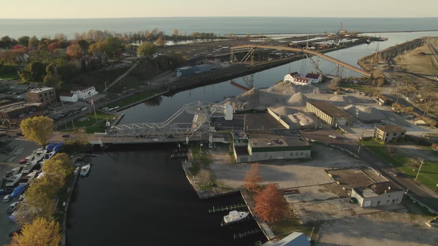 Aerial view of car driving on a bridge over a river and boats parked