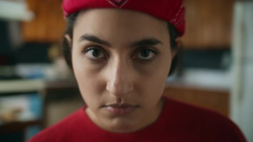 Woman standing glaring in kitchen curls her lip in a sneer