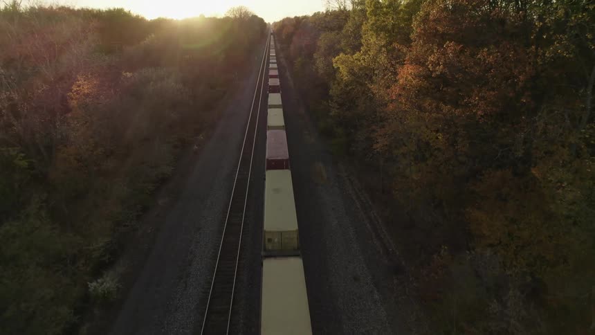 A train is moving on train tracks at dusk