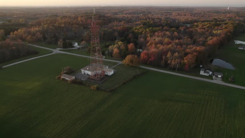 An aerial view of a rural tower and buildings in autumn