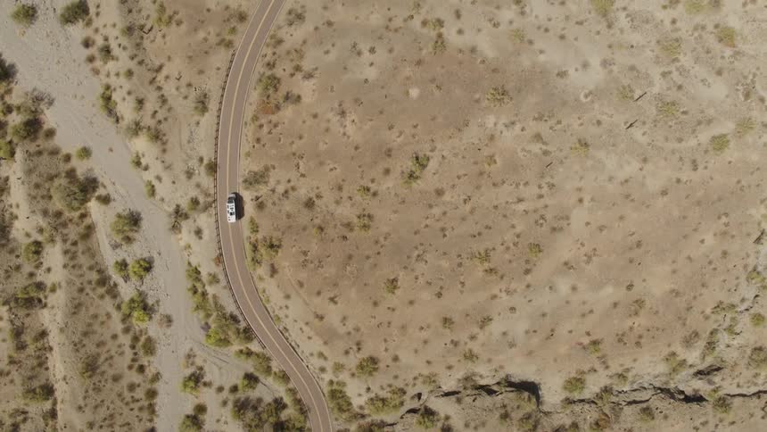 Aerial view of white van driving on highway in the desert