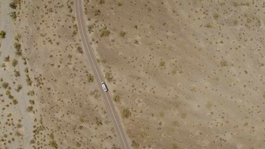 Aerial view of white van driving on highway in the desert