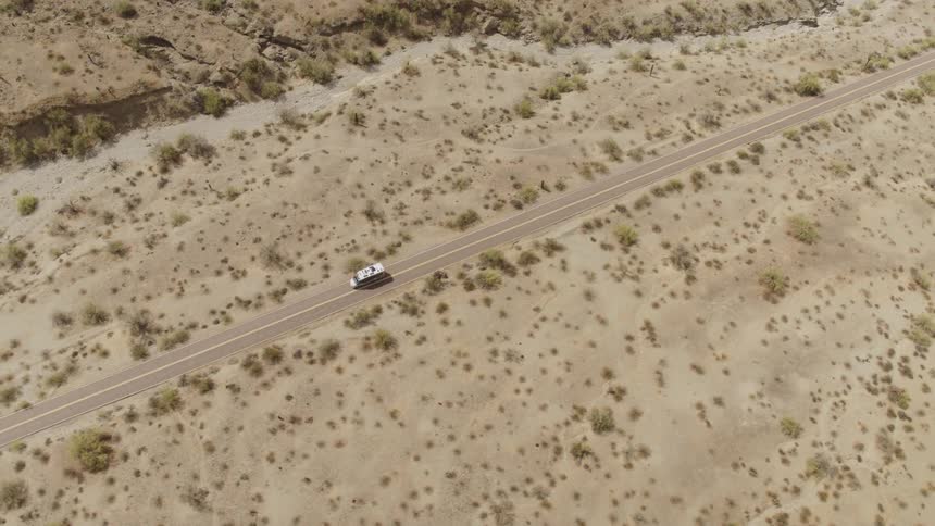 Aerial view of white van driving on highway in the desert