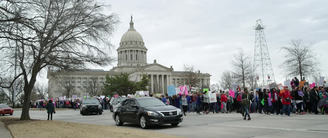 Protesters with signs walk in the street