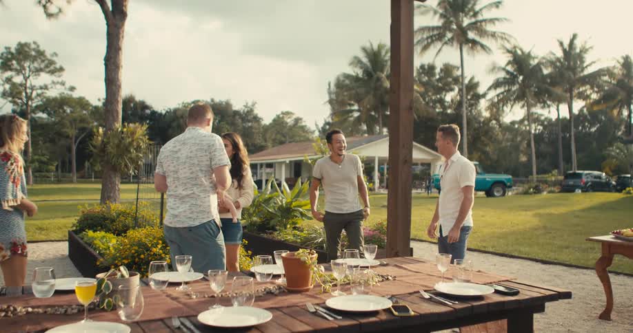 Friends talks while standing outdoors near table