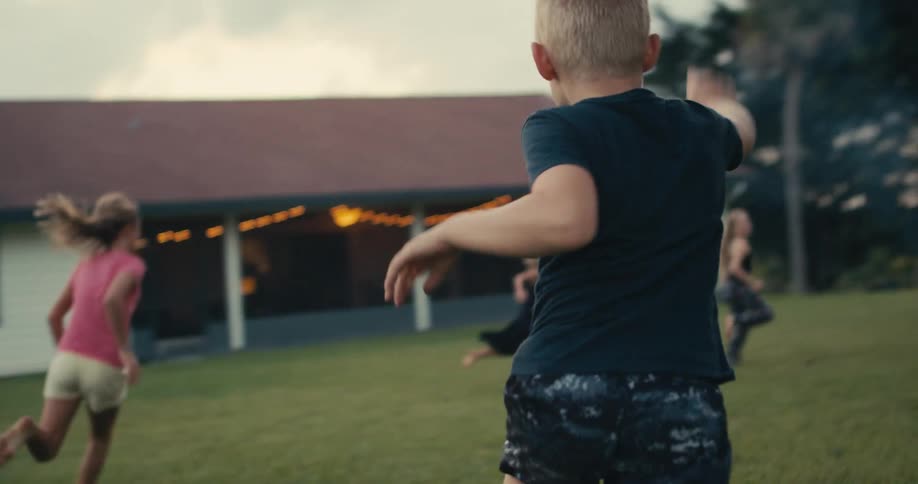 Children run around playing in the yard