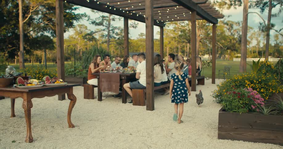 People are sitting at a table outdoors having a picnic