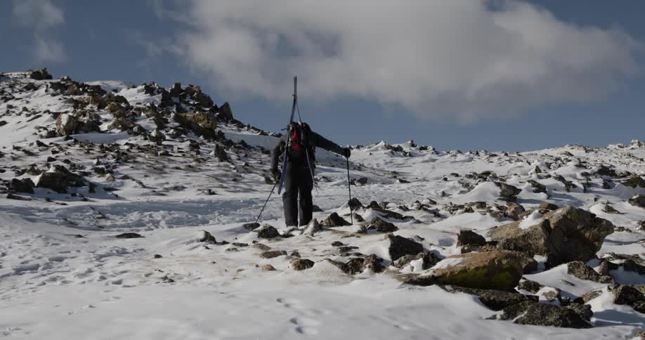 A skier is climbing up the mountain