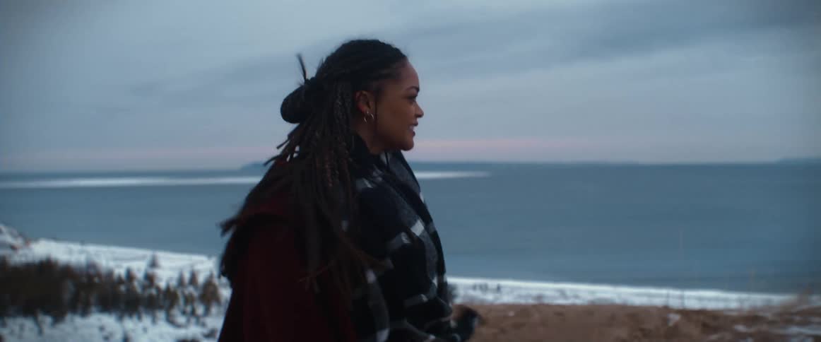 A woman is walking outdoors in winter by the coast