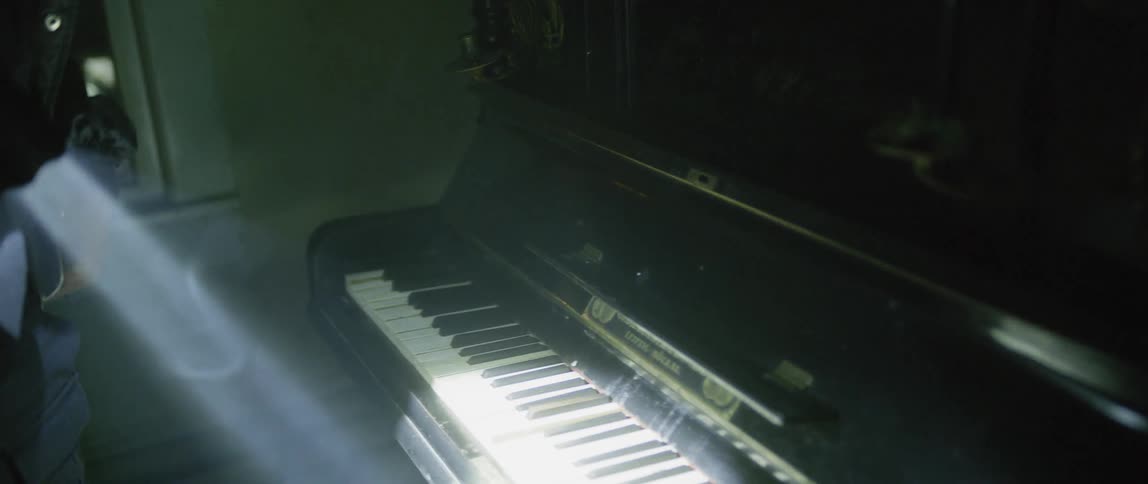 Flash lighted security guard looks around then plays note on piano