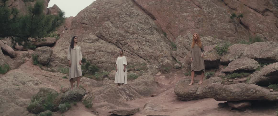 Three women stand on the rocks