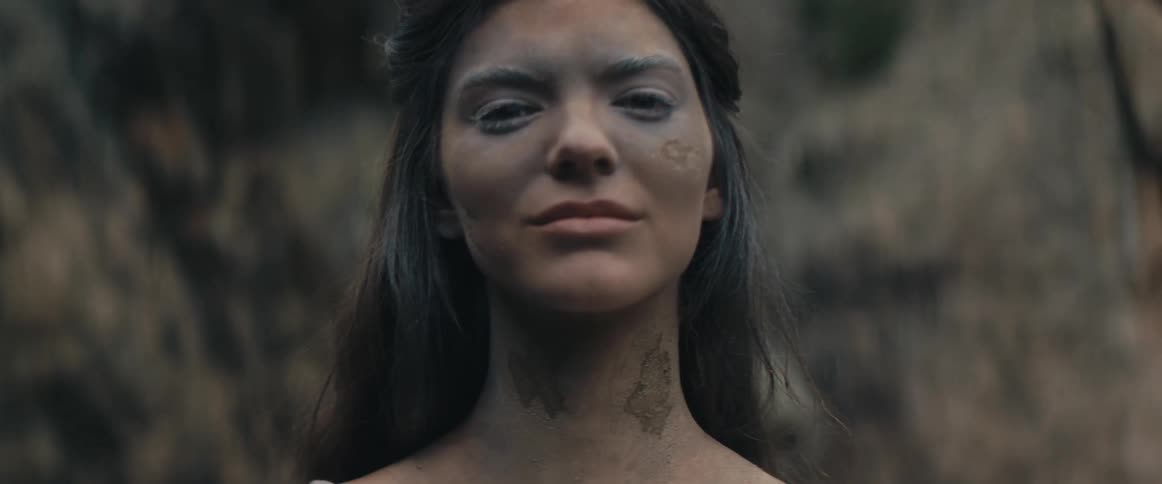 A woman is smiling by the rocks