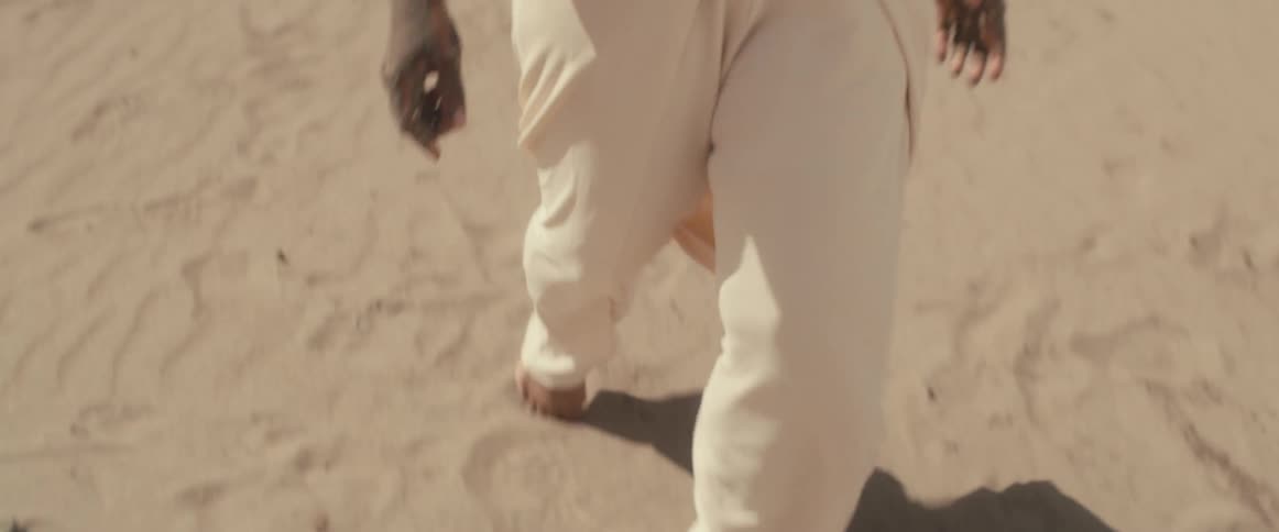 A woman is walking in the desert barefoot