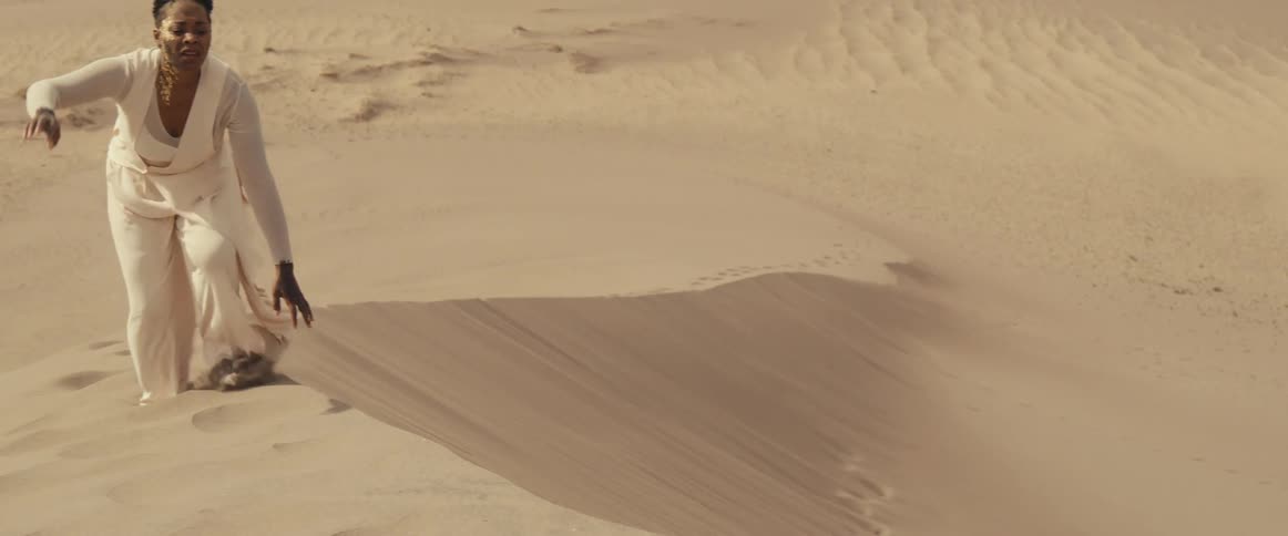 A person is walking through a desert