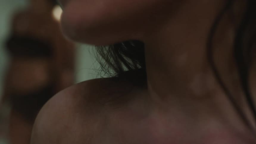 Partial view of a womans face showing her nose and mouth and then moving down to the top of her chest