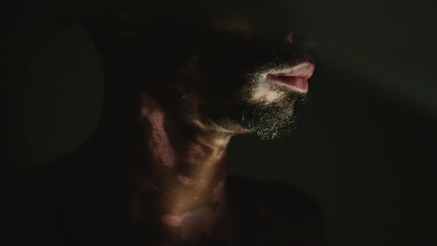 Close up of the bottoms of a mans face and his neck as he stands in one spot