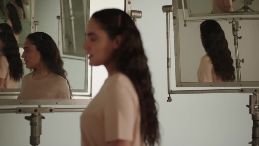 A portrait of a woman in a room full of mirrors