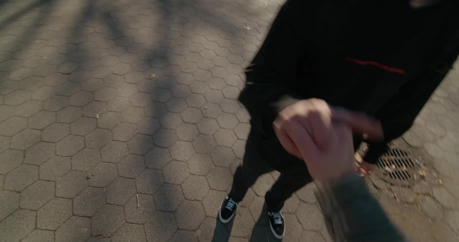 Two teenagers high fiving outside on a sunny fall day