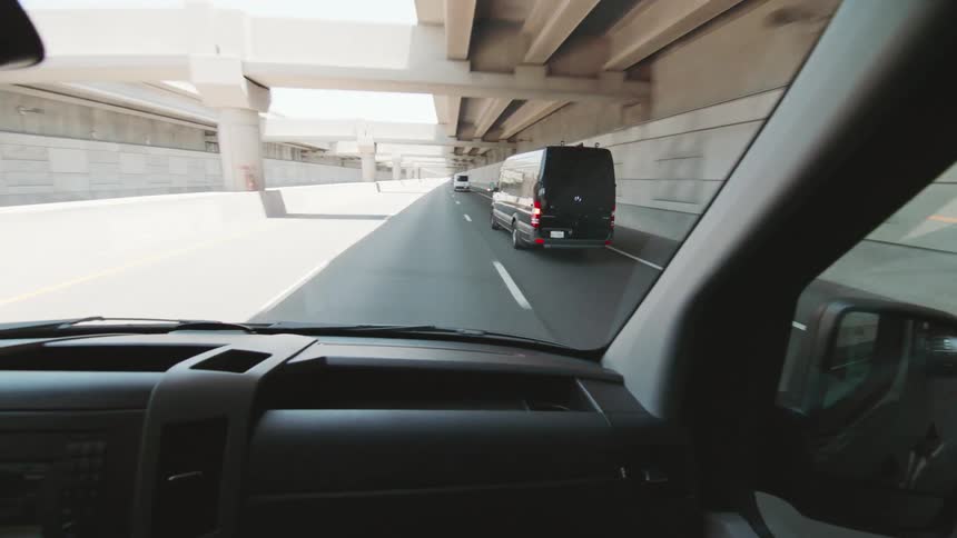 A man is driving his van down the freeway