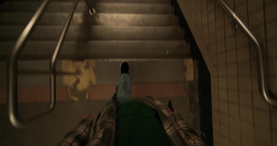 A man jogs down the steps and walks to the turnstile of a subway station