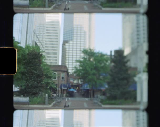 Car drives past intersection between skyscrapers
