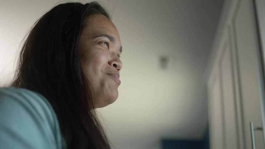 A woman holds a mug and stares off in the distance