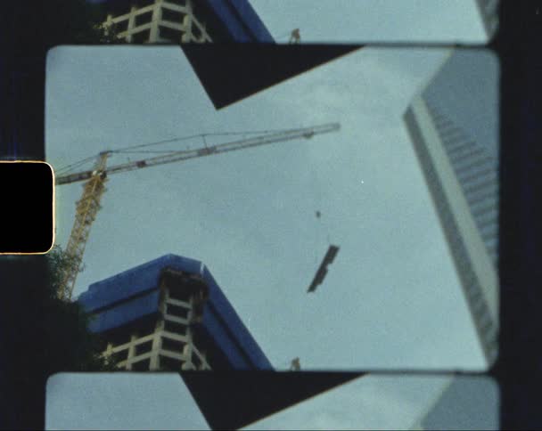 The crane is holding a piece of metal over the building