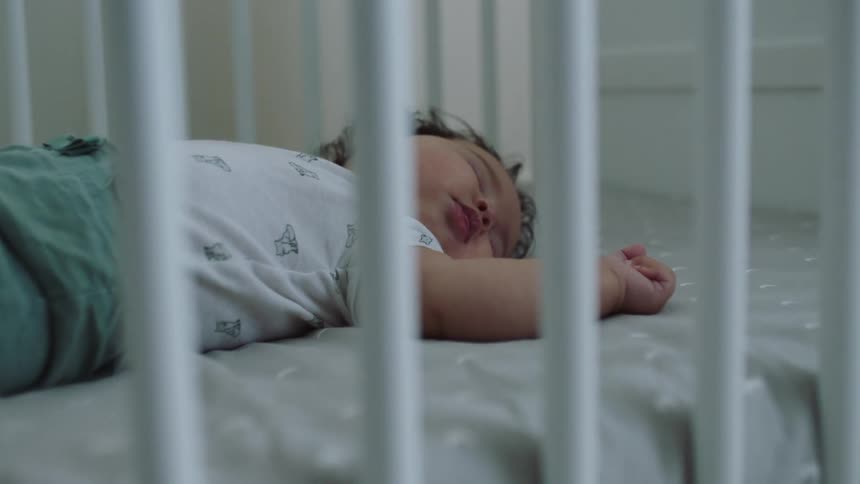 A baby is sleeping in the crib