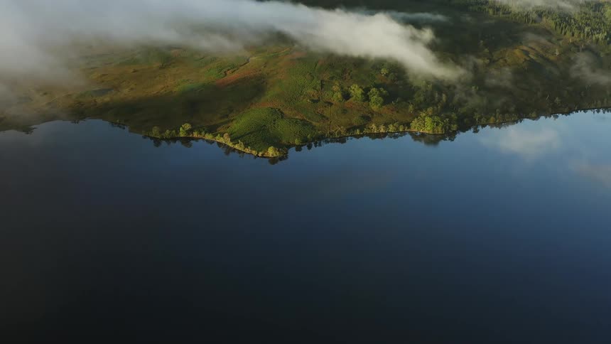 Aerial view of a coastline and clouds reflecting in the water