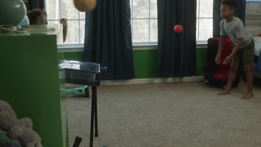 Two brothers play basketball in their bedroom