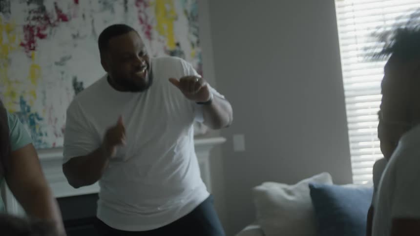 Family dancing around and having fun at the living room