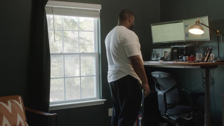 A man standing in a room at a desk
